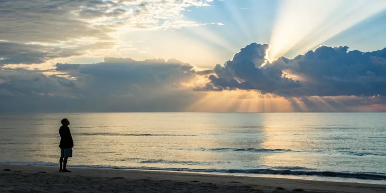 A person experiencing a spiritual awakening while watching the sunrise over the ocean.