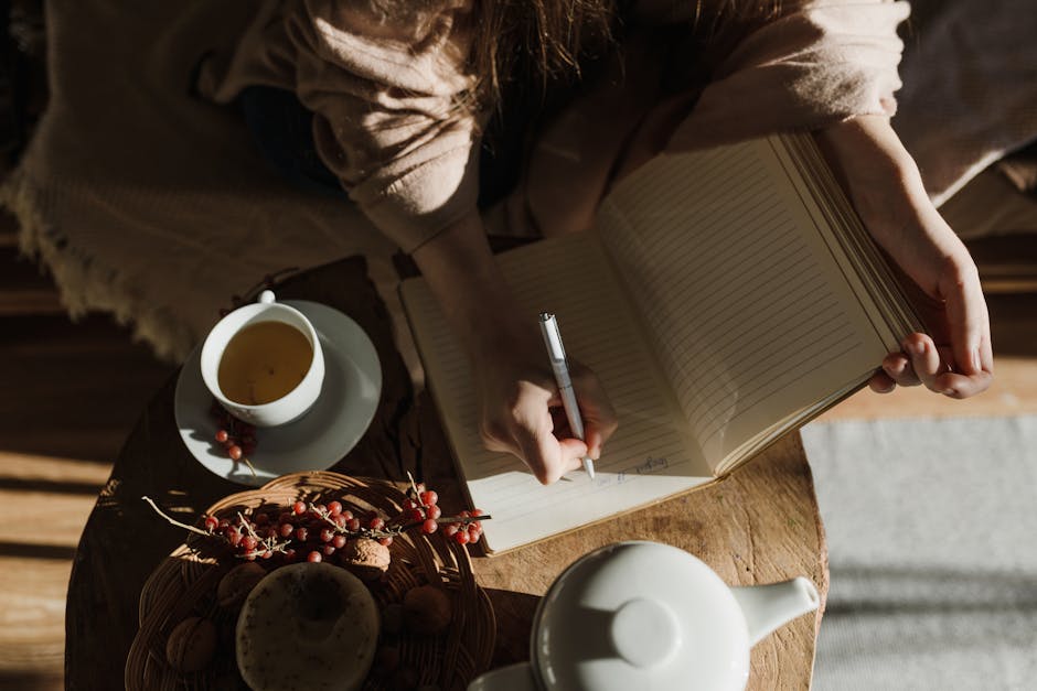A person writing reflections in a journal during a peaceful morning study session representing the daily practice of ACIM Workbook lessons