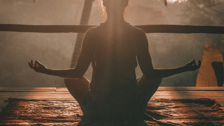 Warm golden light surrounding a person in peaceful meditation representing inner healing and emotional restoration
