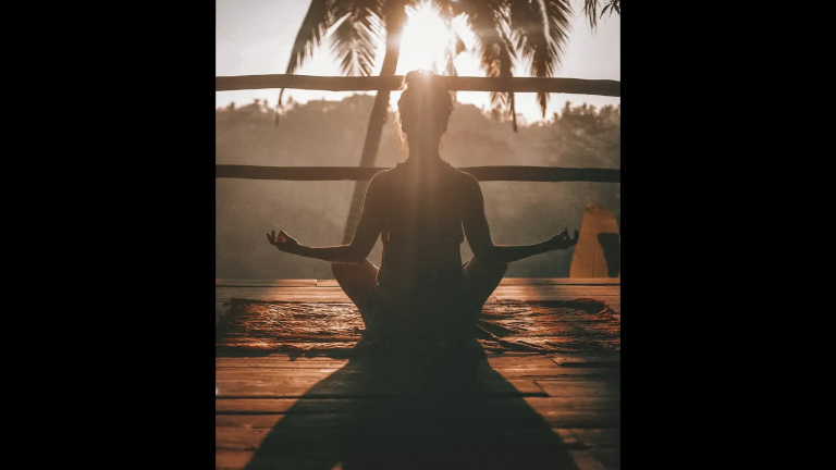 Person meditating in golden light representing the contrast between spiritual peace and hidden emotional pain