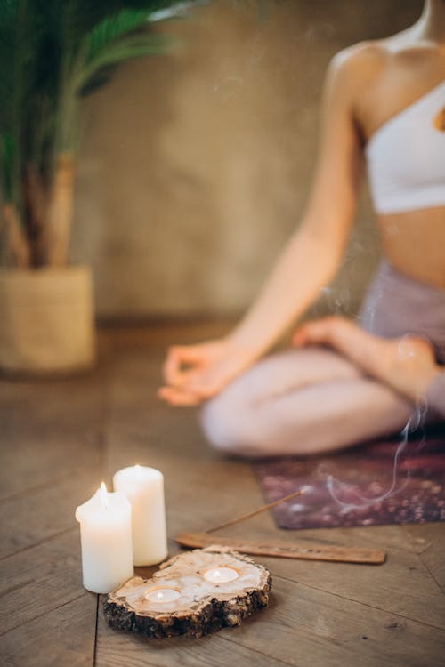 Person meditating in nature surrounded by synchronicity symbols like butterflies, 11:11 clock, and birds in formation