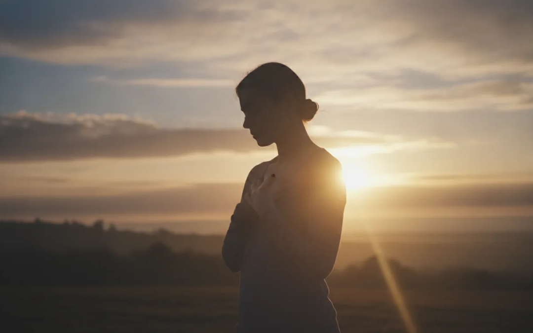 A peaceful person reflecting at sunrise