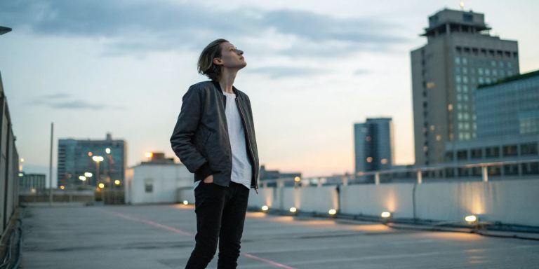 Person on a rooftop at sunset, ready to forgive themself and let go of past mistakes.