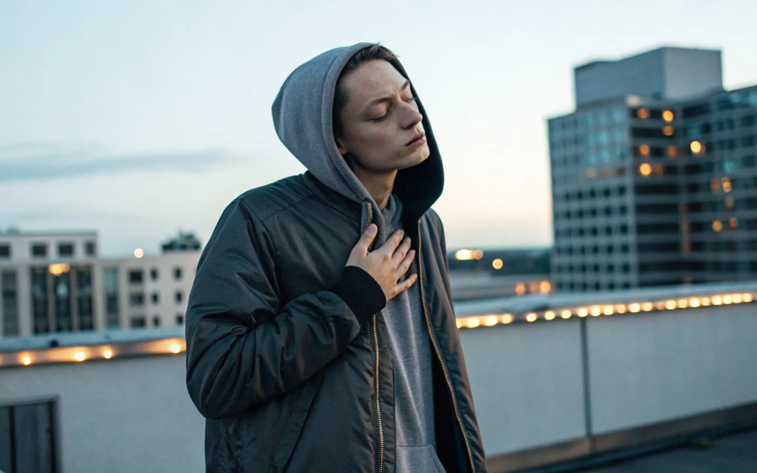 A person with their hand on their chest at sunset, beginning to heal deep emotional wounds.