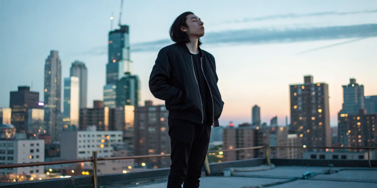 A person channels divine healing energy on a rooftop at sunset.